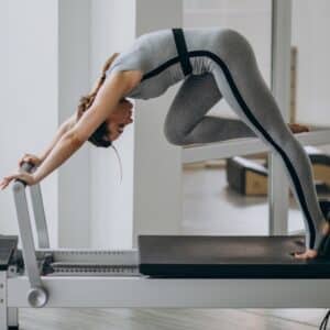 mujer haciendo pilates en maquina