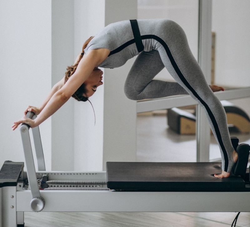 mujer haciendo pilates en maquina