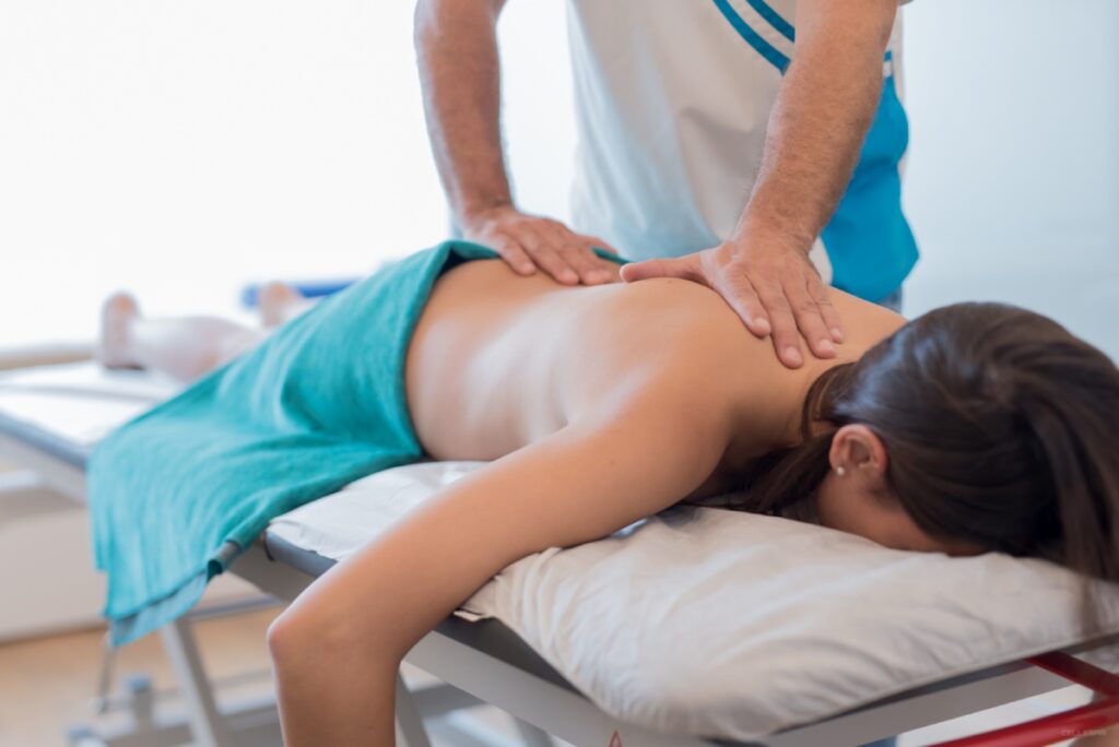 fisio masajeando la espalda de una paciente