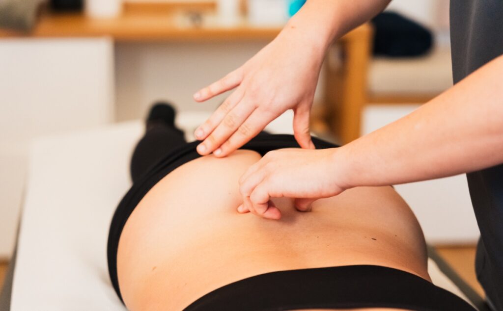 fisioterapeuta pretando la columna de una paciente