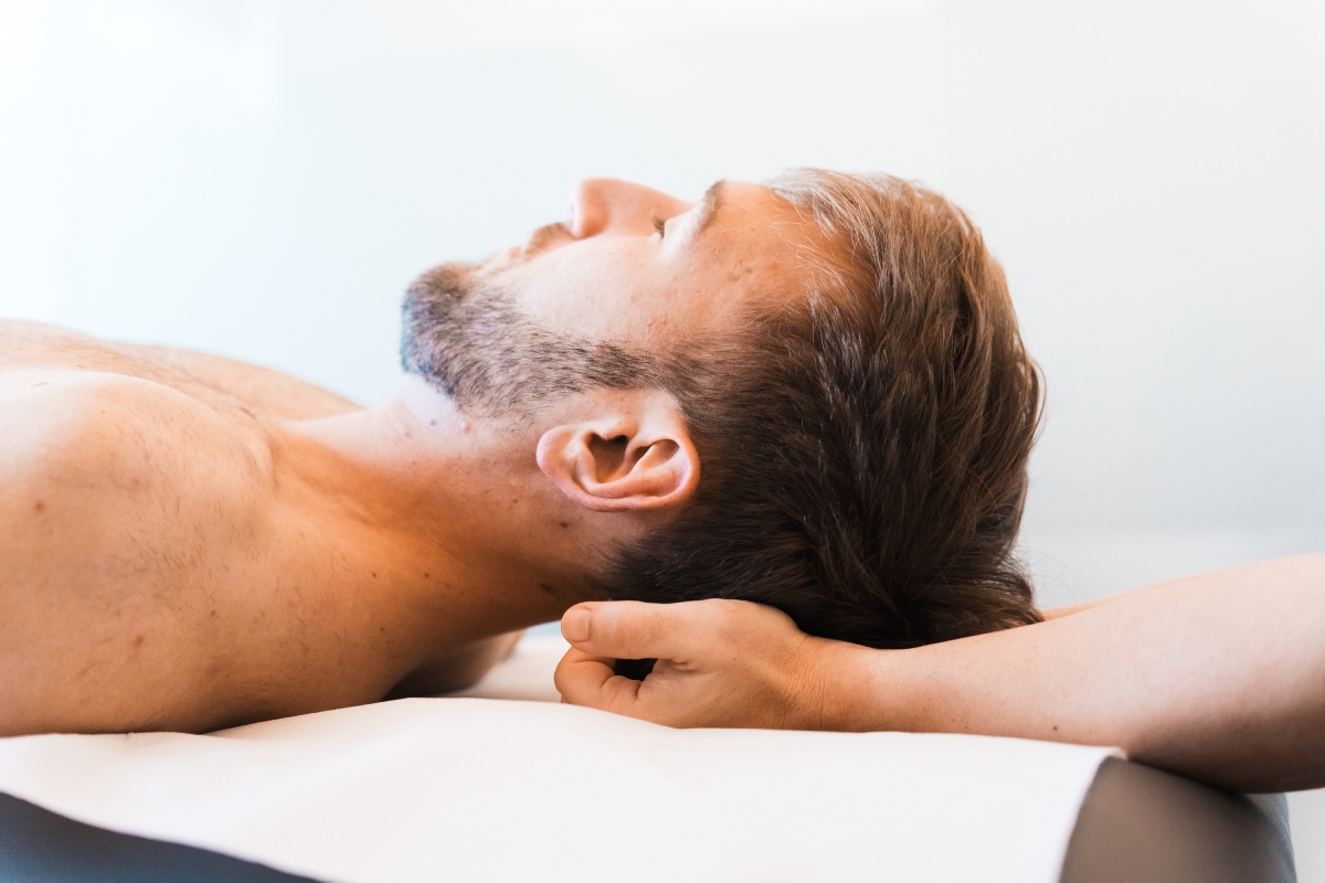 osteopata aplicando presion en la cabeza del paciente